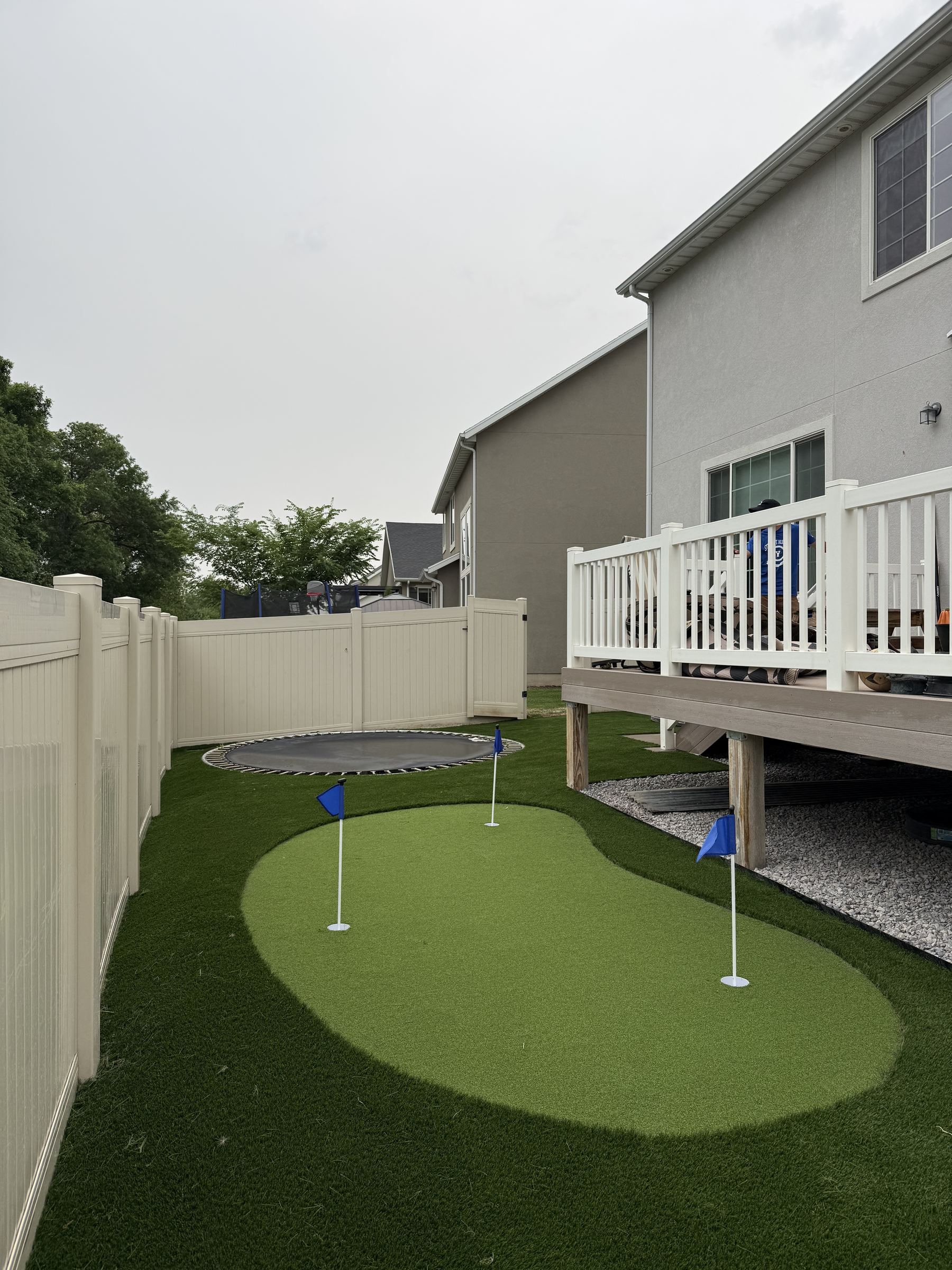 Multi-cup putting green with trampoline surround, narrow side yard